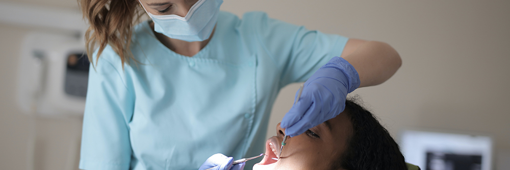 A woman providing dental care to a person's mouth.