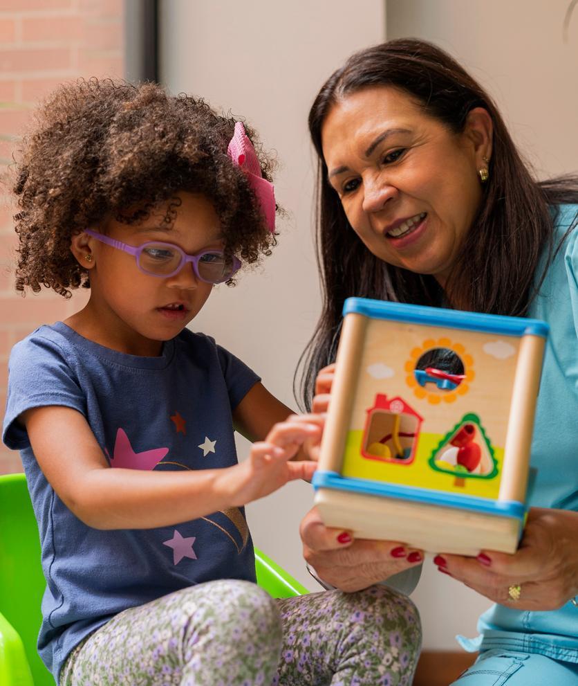 Child and a teacher playing in classroom