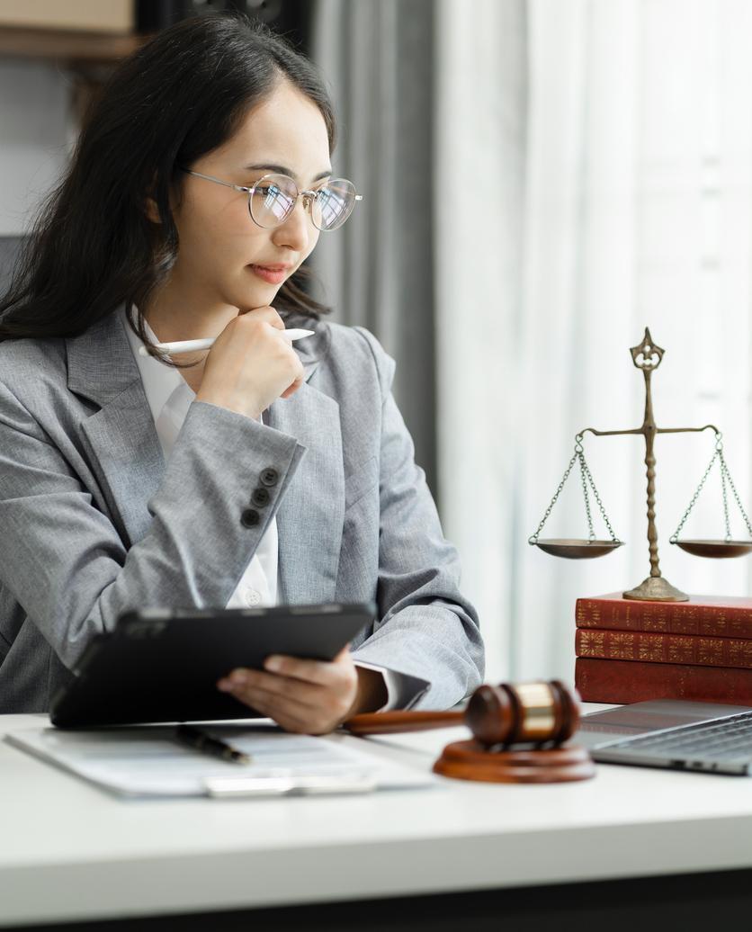 Woman in a business suit, thinking at a desk