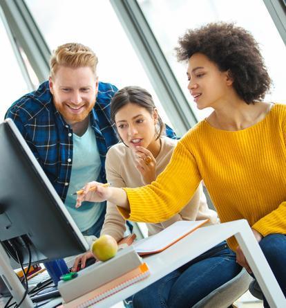 Three people talking and looking at a computer screen
