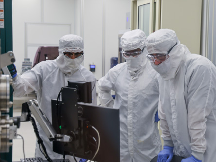 People in the clean room looking intently