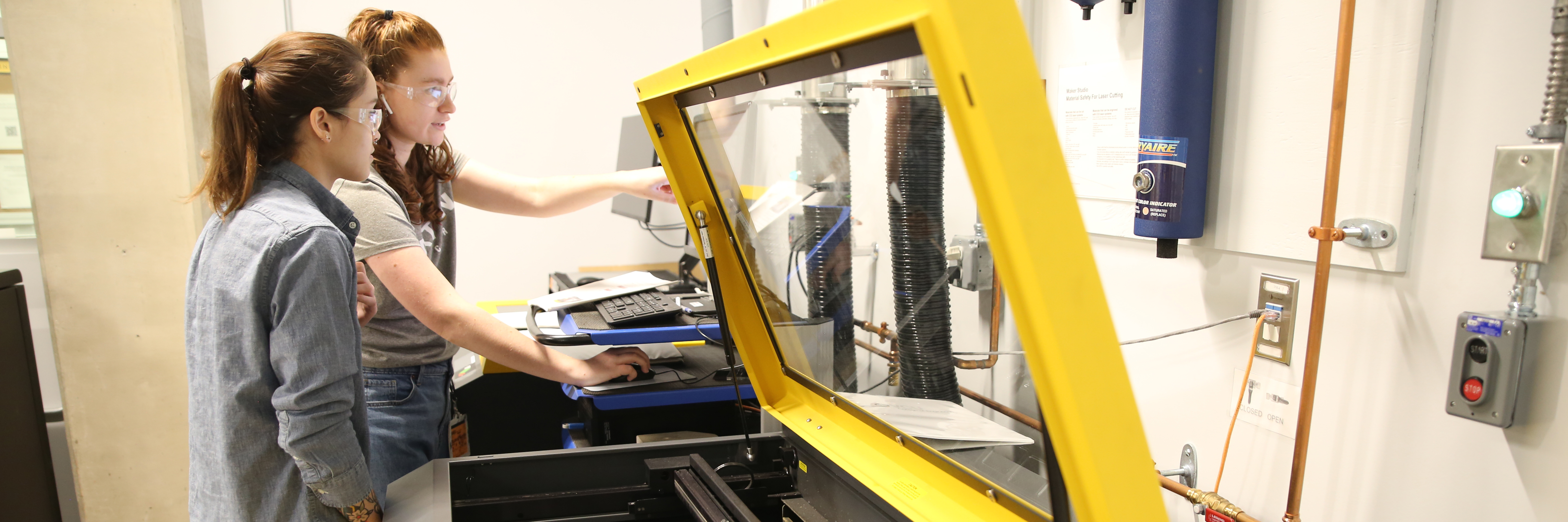 Photo of students looking at a 3D printer.